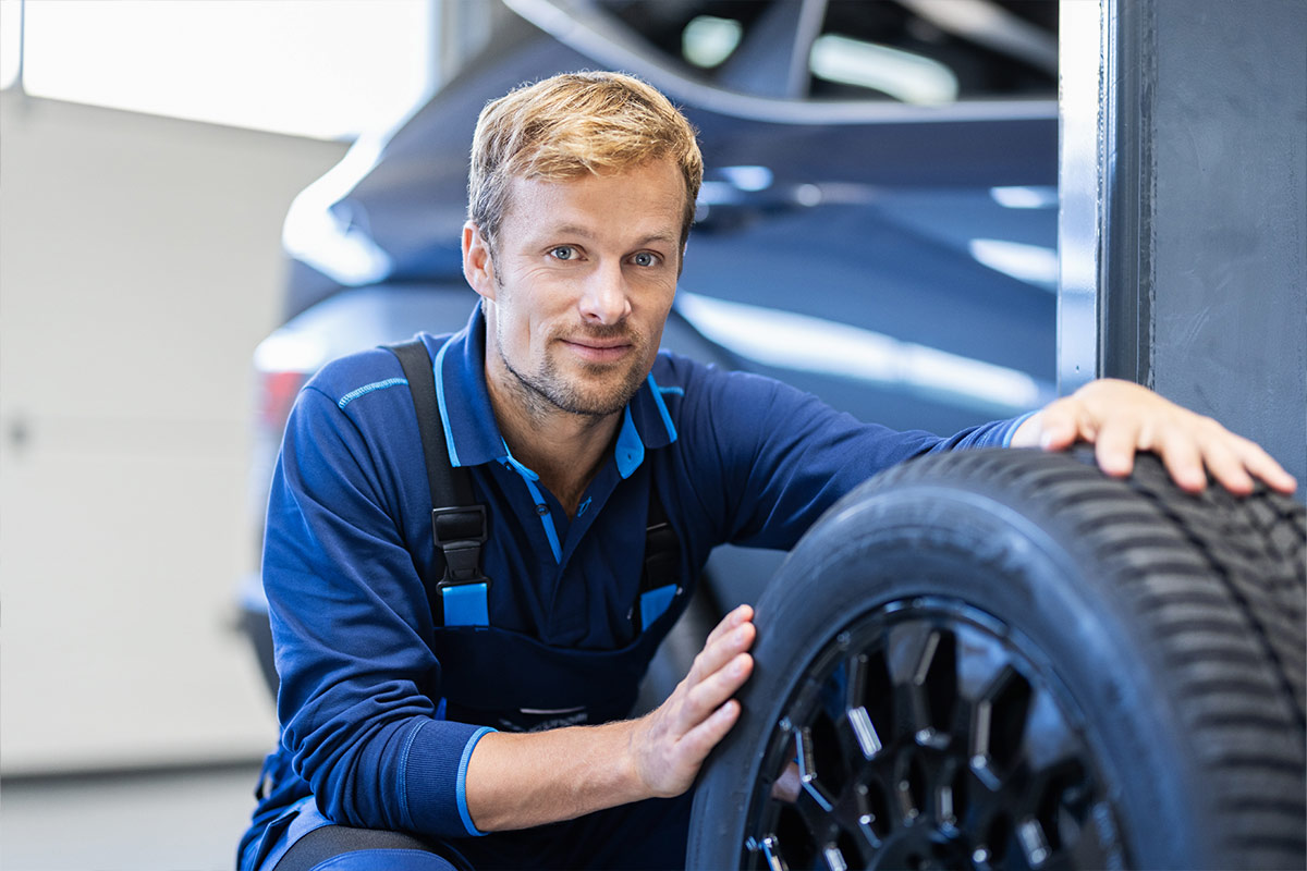 Hyundai Service Mitarbeiter in der hocke mit einem Reifen in der Hand